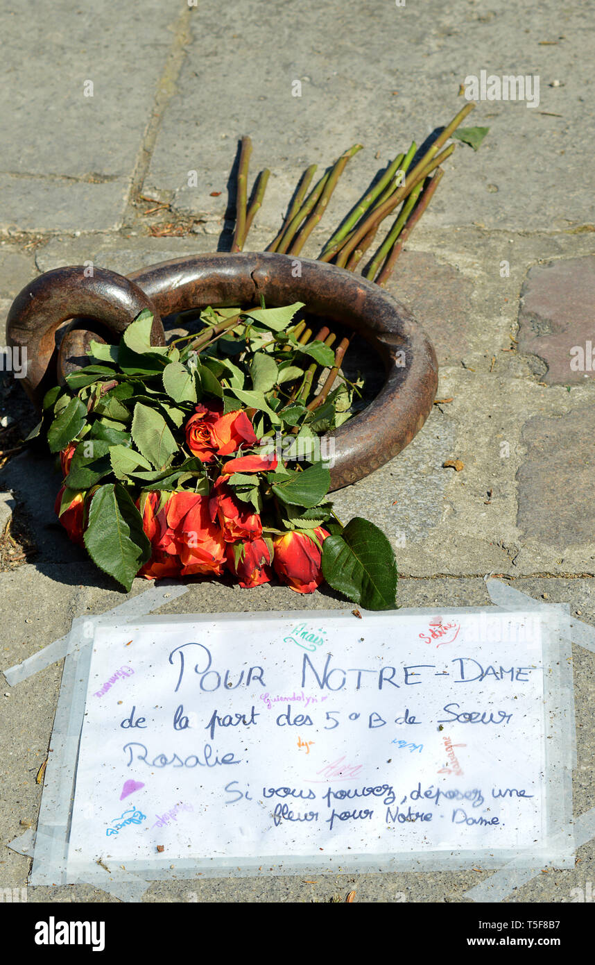 PARIS, Frankreich - 19 April 2019: Blumen von einer Grundschule Klasse außerhalb der Feuerwehr links beschädigt Kathedrale Notre Dame. Stockfoto