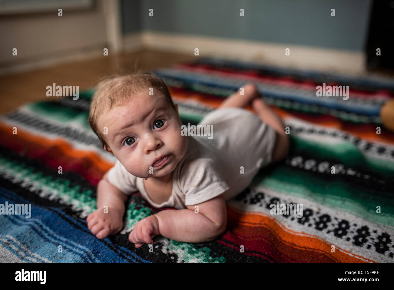 Drei Monate altes Baby boy Verlegung auf Bunt gestreifte Decke Stockfoto