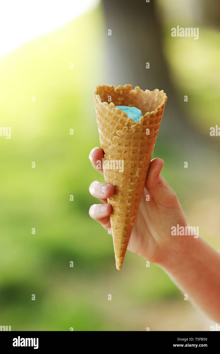 Köstliches Eis schmilzt und fließt an der Hupe in der Hand der Frau. eis Horn in der Hand einer Frau Stockfoto