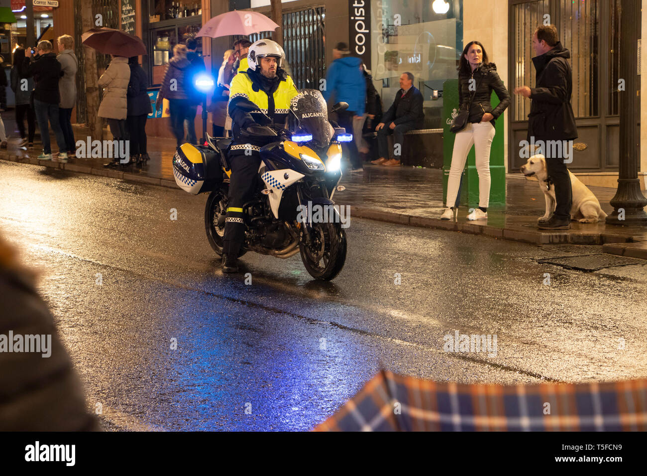 Polizei Motorradfahrer bei nasser Straße patrouillieren 2019 Ostern Parade während der Heiligen Woche in Alicante Spanien Stockfoto