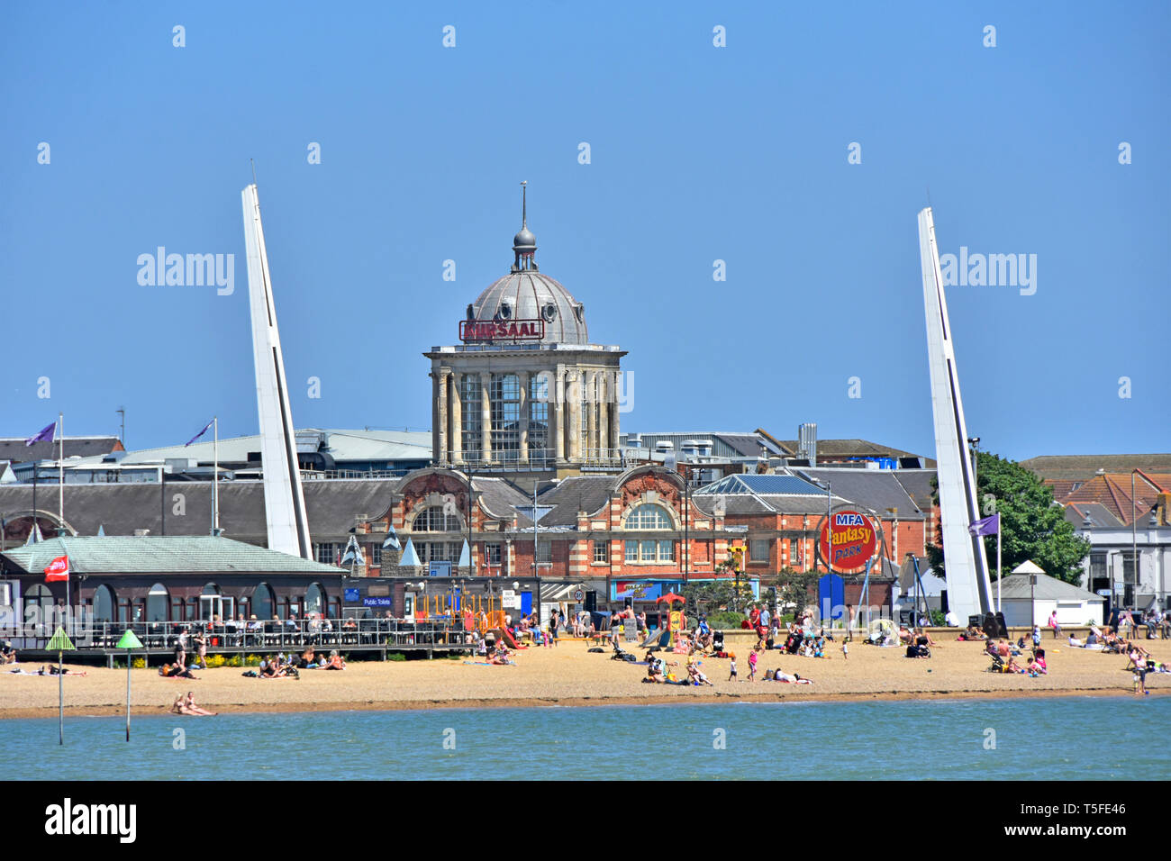 Menschen in Southend on Sea am Meer Familie Strand Kuppel des berühmten viktorianischen Kursaal Amusement Park am Ufer des Flusses Thames Estuary Southend Essex England Großbritannien Stockfoto