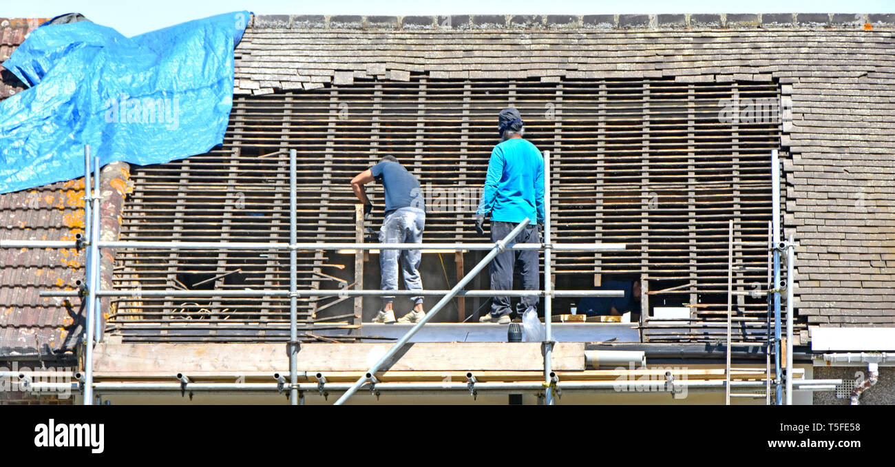Builder Arbeiter auf Gerüst entfernen Dachziegel & Holz in Vorbereitung auf neue dormer Zimmer im Dachgeschoss im Dachgeschoss von Haus Romford East London Großbritannien Stockfoto