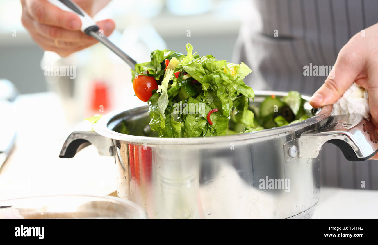 Männliche Hände mischen Organische gehackt Salat Stockfoto