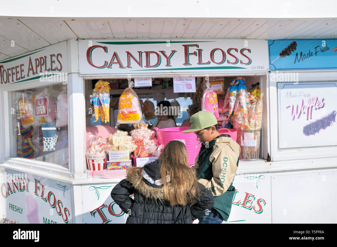 Ein junges Mädchen und Jungen zählen kleine Änderung Geld an einer Zuckerwatte und Süßwaren Palace Pier von Brighton, East Sussex, England, UK Abschaltdruck Stockfoto