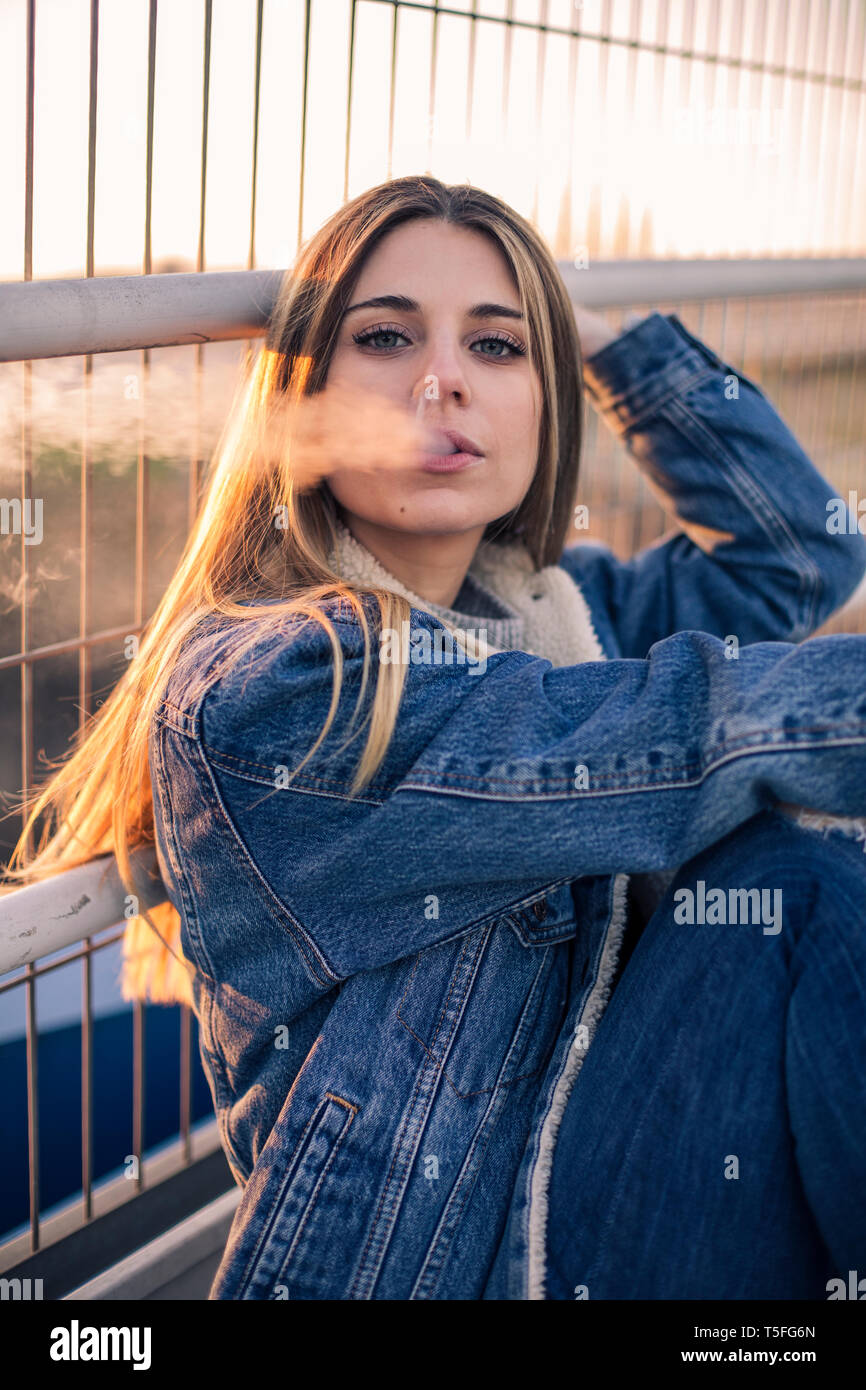 Porträt der jungen Frau Rauch ausblasen Stockfoto