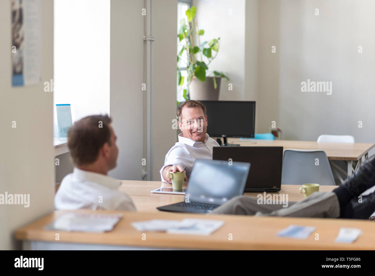 Zwei entspannt Geschäftsleute mit Laptops im Büro Stockfoto