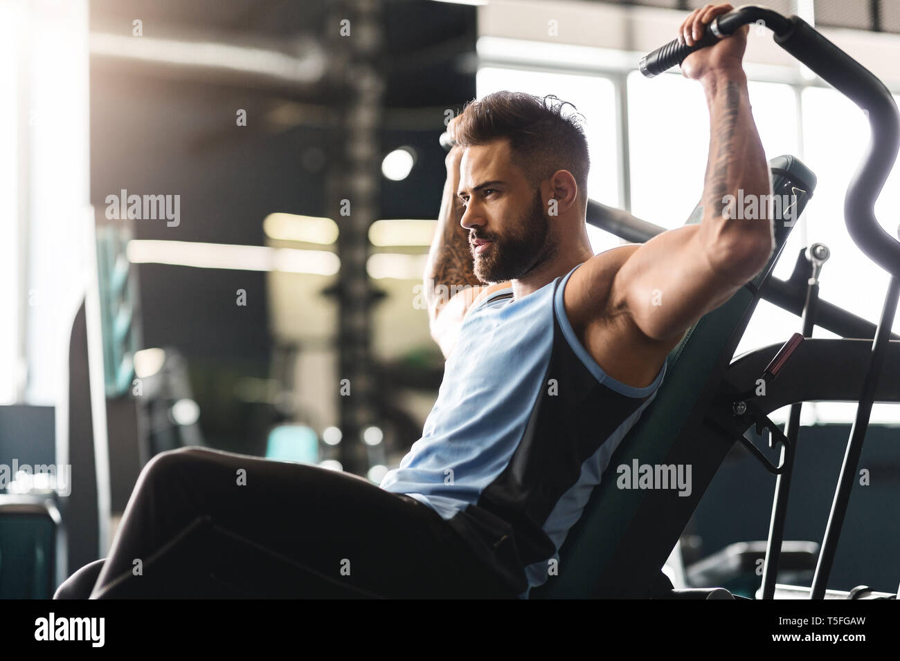 Junger Mann Trainieren mit Trainingsgeräten in der Turnhalle, leeren Raum Stockfoto