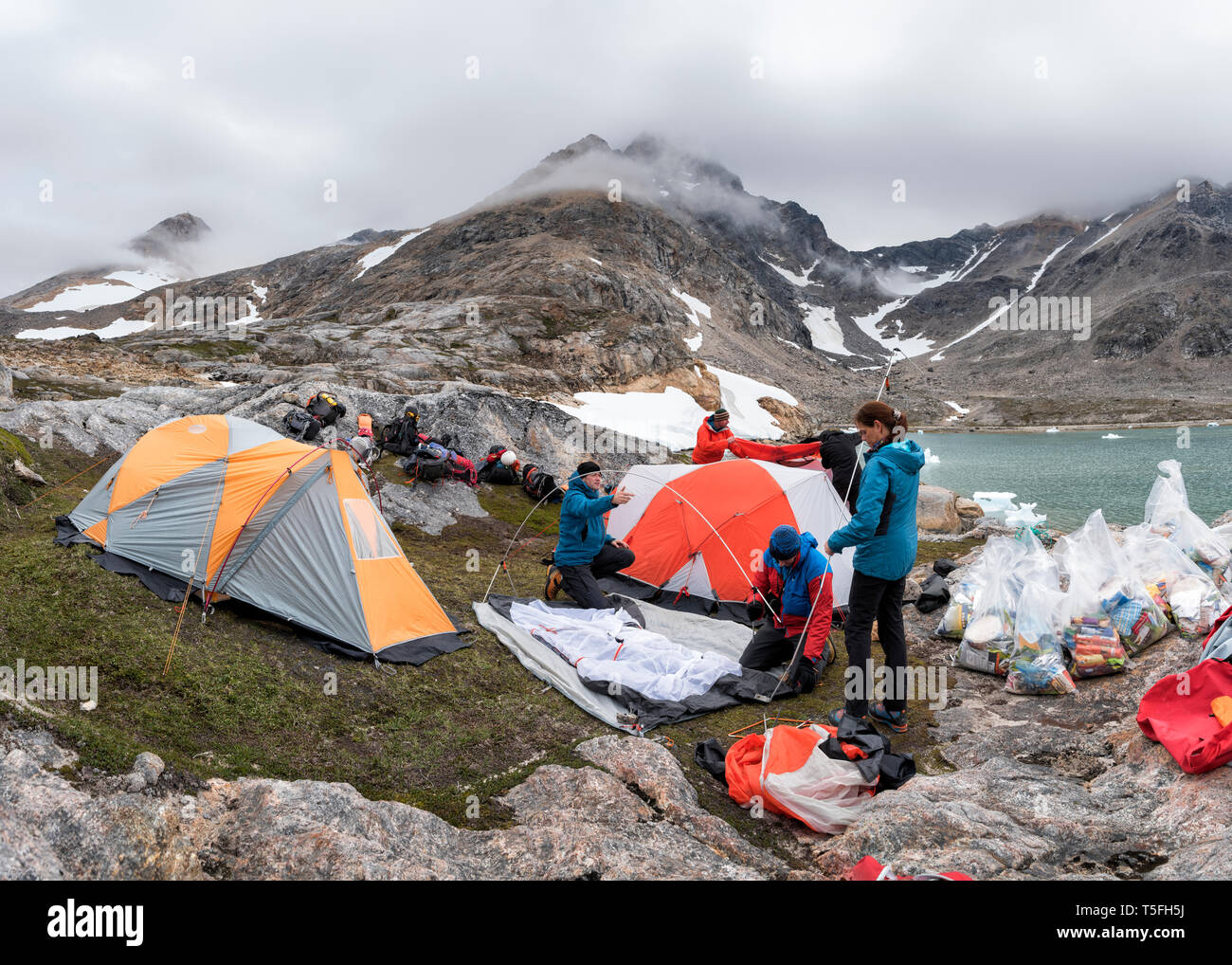 Grönland, Sermersooq, Kulusuk, Schweizerland Alpen, Gruppe von Menschen die Einrichtung von Lager Stockfoto