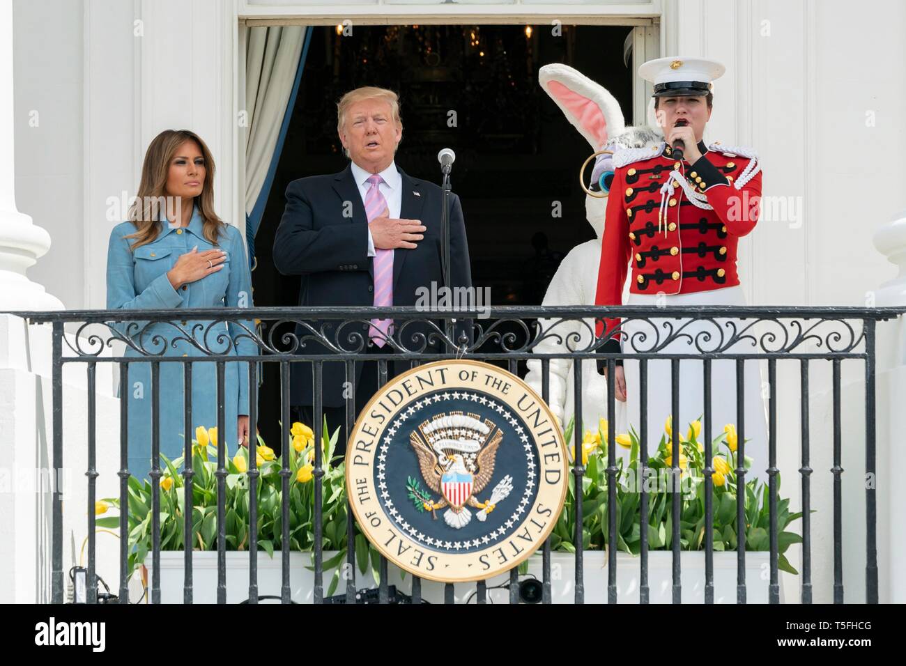 Us-Präsident Donald Trump und First Lady Melania Trump stehen für die Nationalhymne bei Beginn der jährlichen Weiße Haus Easter Egg Roll Event auf dem Südrasen des Weißen Hauses April 22, 2019 in Washington, DC. Dies ist das 141 Jahr für das Frühjahr stattfindenden Veranstaltung. Stockfoto
