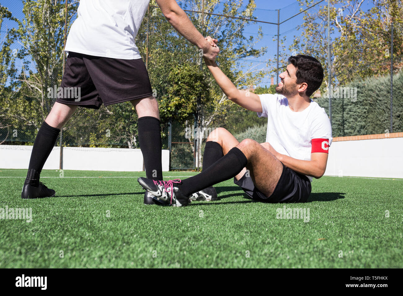 Fußball-Spieler helfen einen verletzten Spieler während eines Spiels Stockfoto