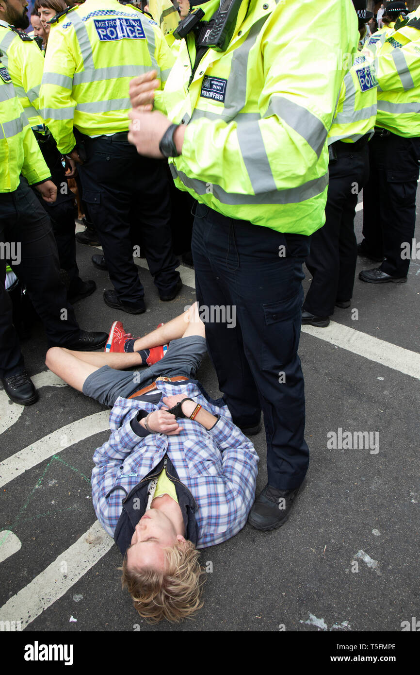 Polizei und Demonstranten entfernen, da sie in der Oxford Street in der Nähe des Marble Arch Camp aus Protest, dass die Regierung nicht genug um die katastrophalen Klimawandel zu vermeiden und zu verlangen, dass sie die Regierung radikale Maßnahmen zu ergreifen, um den Planeten zu retten, die am 24. April 2019 in London, England, Vereinigtes Königreich zu löschen Klimawandel Aktivistinnen aus dem Aussterben Rebellion Gruppe versuchen. Aussterben Rebellion ist ein Klimawandel Gruppe begann im Jahr 2018 und hat eine riesige Fangemeinde von Leuten zu friedlichen Protesten begangen. Stockfoto