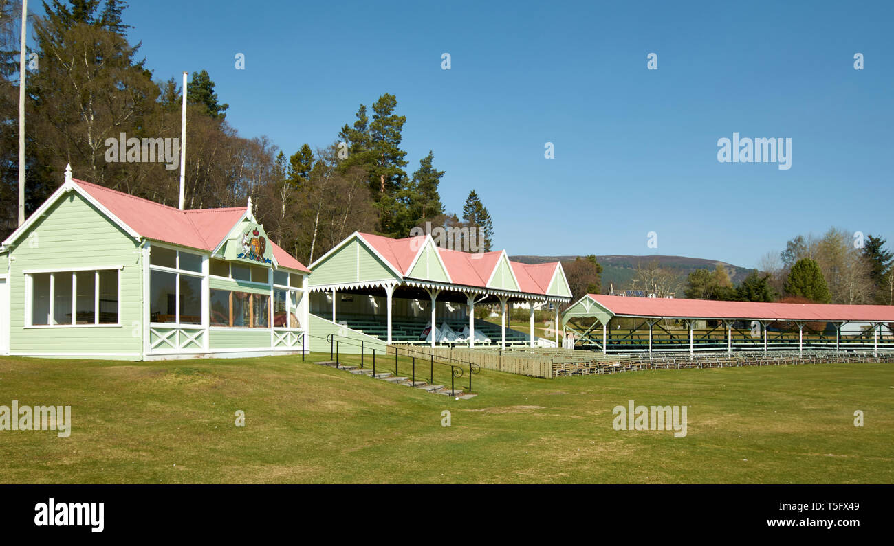 BRAEMAR ABERDEENSHIRE SCOTLAND THE DUKE OF ROTHESAY HIGHLAND GAMES PAVILLON ÜBERDACHTE ROSA UND GRÜN STEHT UND SITZEN RUND UM DEN SPORTPLATZ Stockfoto