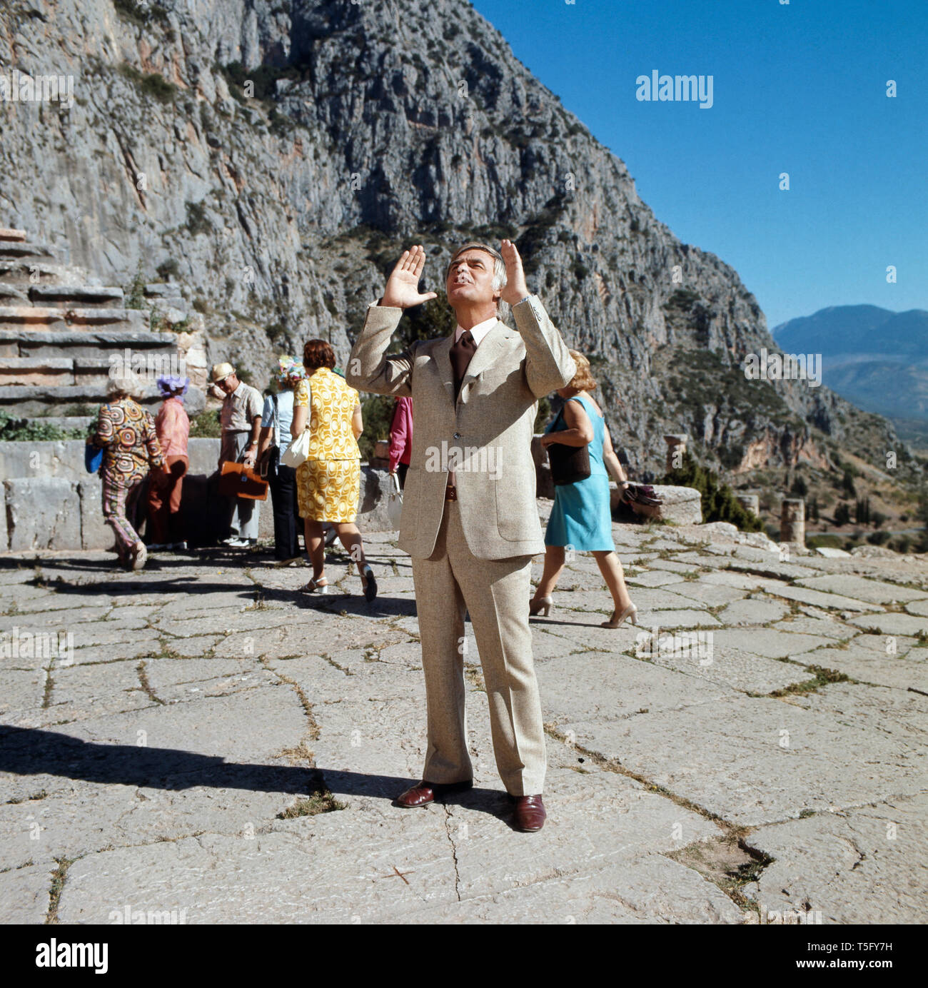 Joachim Fuchsberger hält eine dramatische Anspache im Theater von Delphi, Griechenland 1970er. Joachim Fuchsberger macht einen dramatischen Verweis auf das Theater von Delphi, Griechenland 1970 s Stockfoto