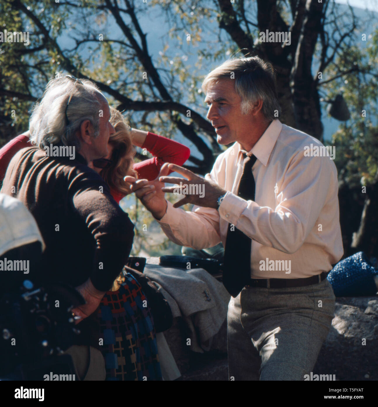 Joachim Fuchsberger gestikulierend erklärt einer anderen Person etwas, Spanien 1970er. Joachim Fuchsberger sagt jemand anderes etwas Gestik, Griechenland 1970 s Stockfoto