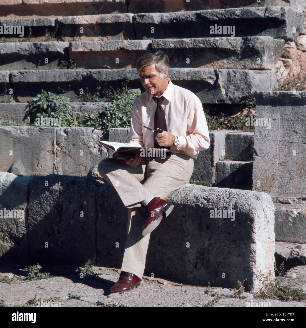 Joachim Fuchsberger liegst ein Skript in einem altertümlichen Theater Ca. 1970er. Joachim Fuchsberger liest ein Script in einem antiken Theater circa 1970 s Stockfoto