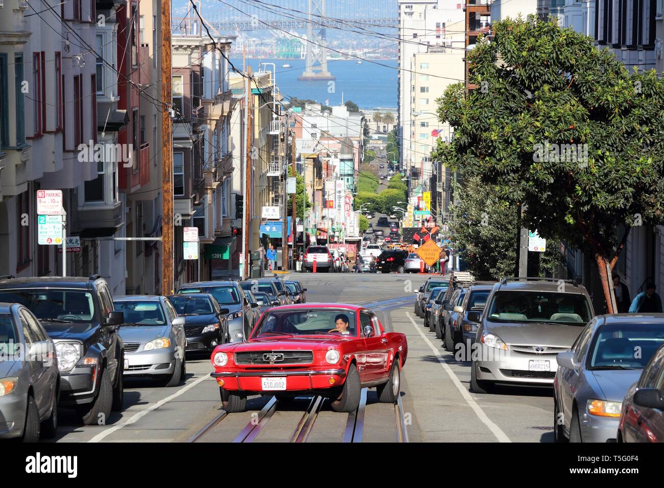 SAN FRANCISCO, USA - April 9, 2014: Frau Antriebe roten Mustang in Chinatown in San Francisco, USA. San Franciscos Chinatown ist der größte chinesische Commun Stockfoto