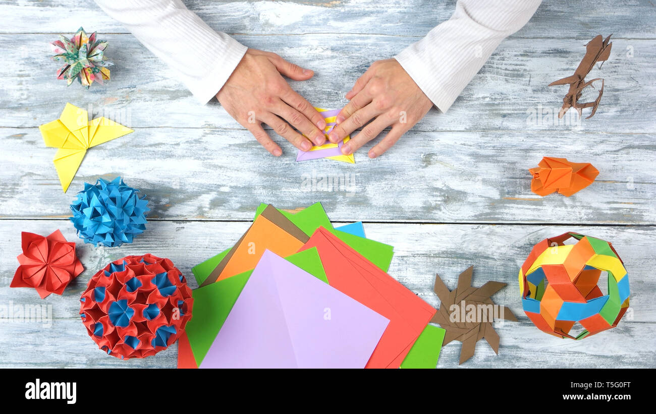Männliche Hände falten origami Spielzeug. Stockfoto