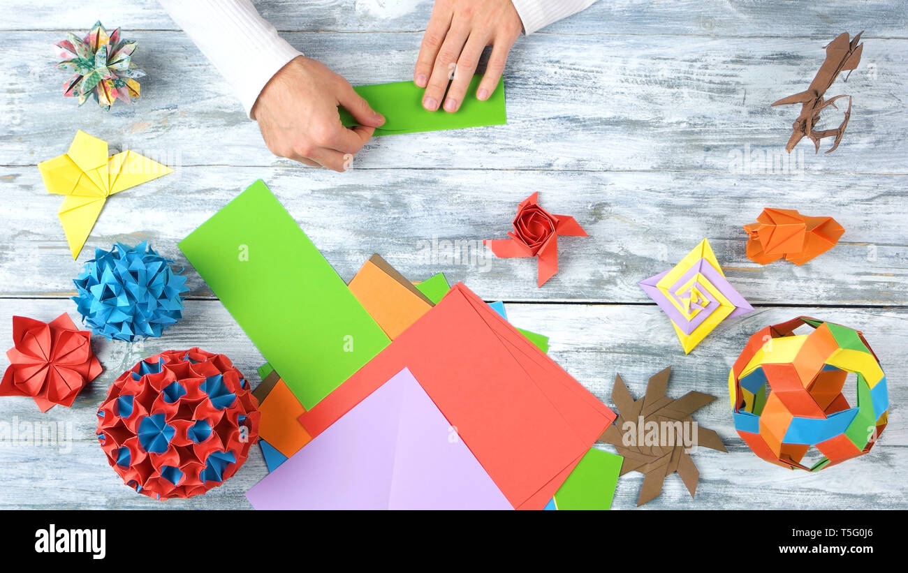 Hände, Origami mit dem Grünbuch. Stockfoto