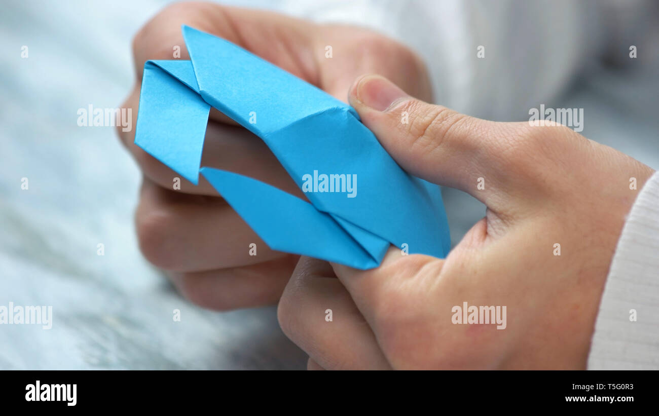 Close up männliche Hände falten origami Figur. Stockfoto