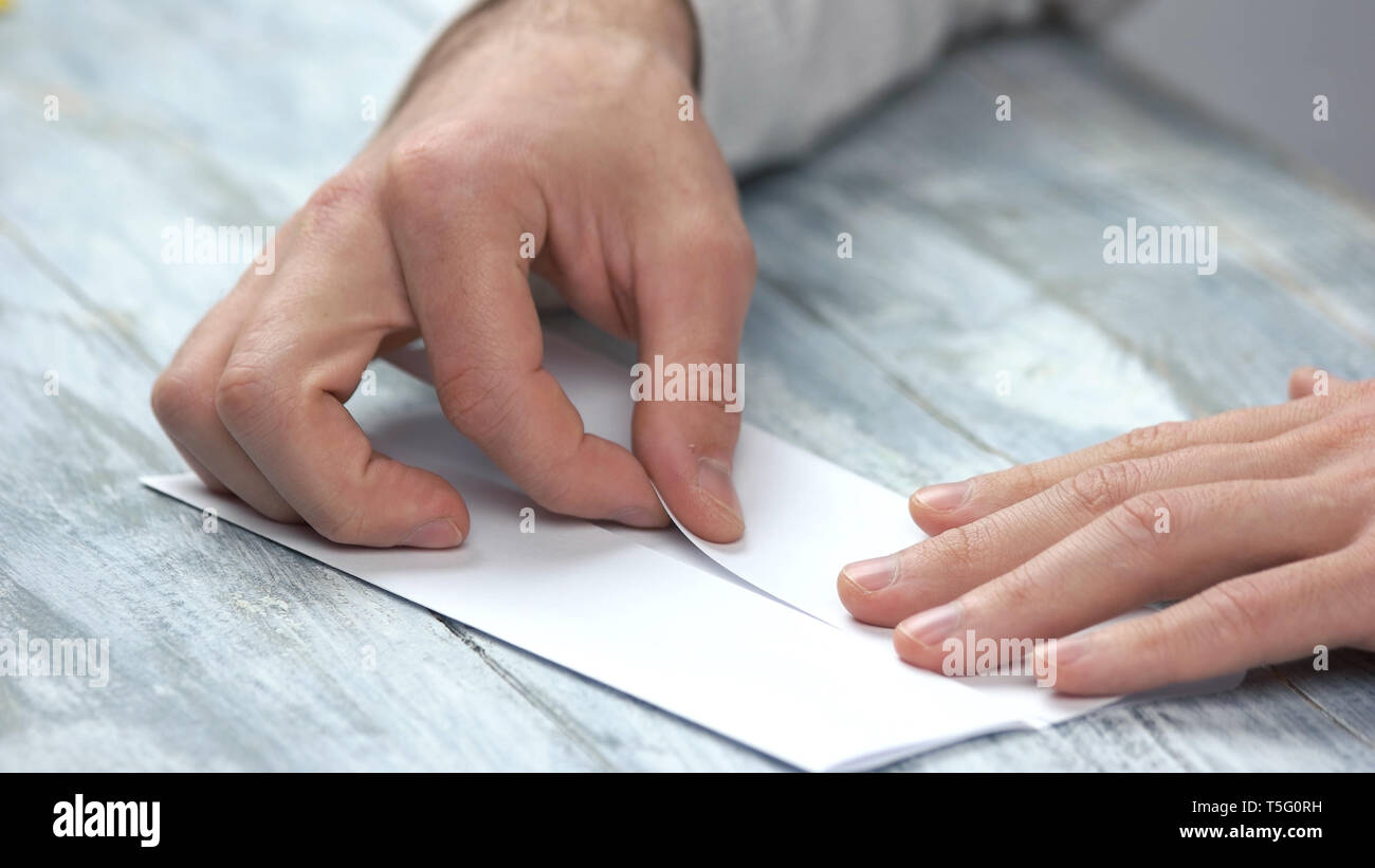 Männliche Hände falten weißes Blatt Papier. Stockfoto