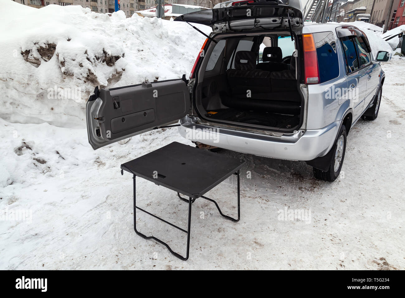 SUV-Auto in Silber mit geöffnetem Kofferraum und Tisch für Picknick in der  Nähe es nach der Reinigung vor dem Verkauf in einem Winter und Schnee  Hintergrund Stockfotografie - Alamy