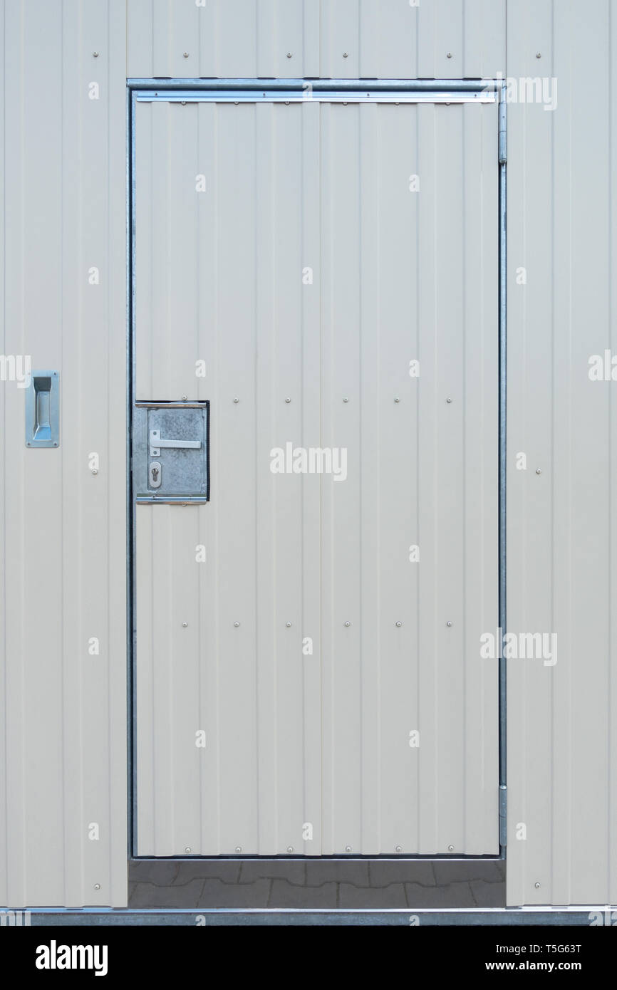 Tür im hellen Fassade eines Industriegebäudes Stockfoto