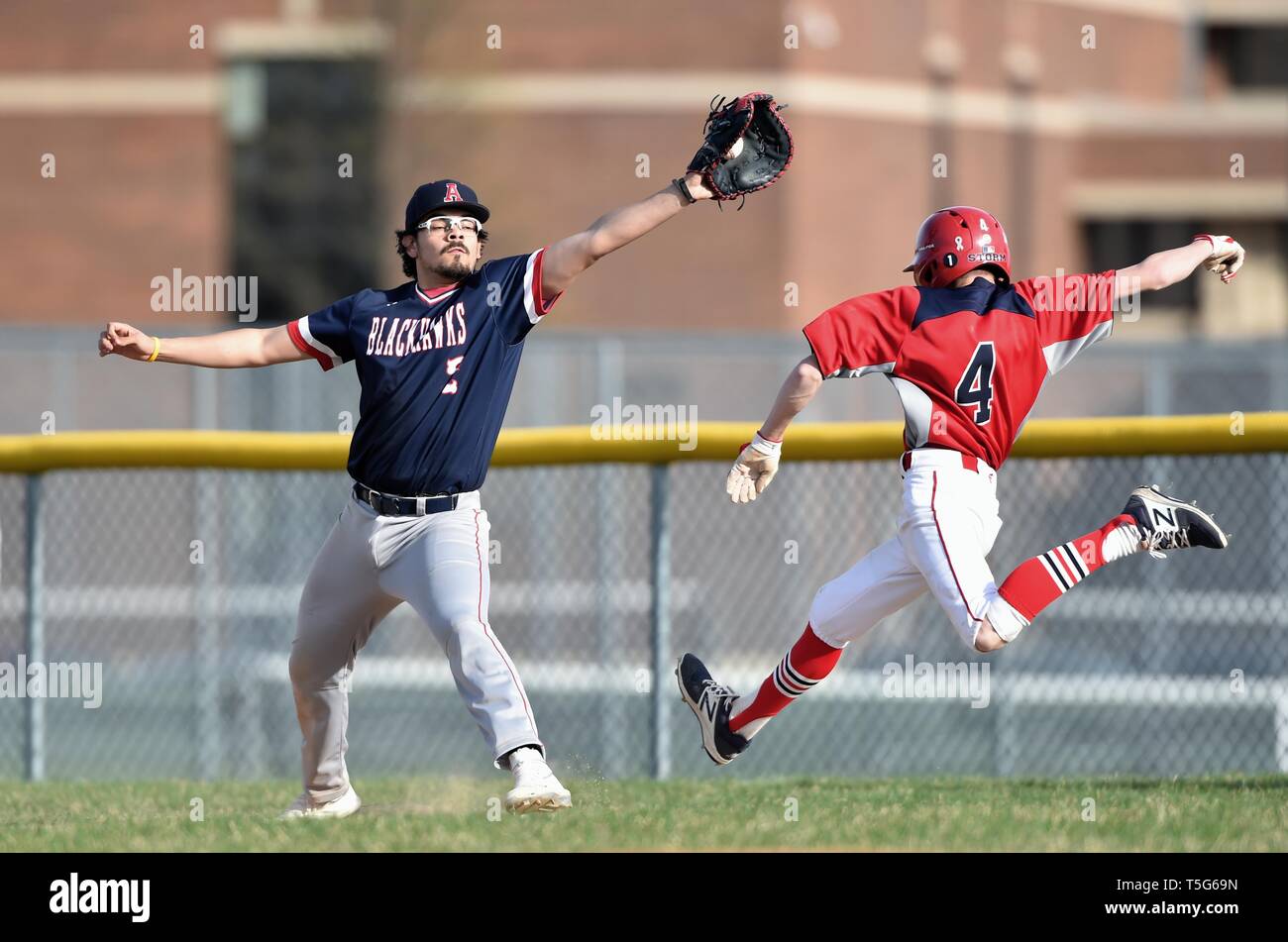 Base Runner auf einem in der Nähe spielen am ersten Base zog sich als der erste Basisspieler dehnte die werfen zu akzeptieren. USA. Stockfoto