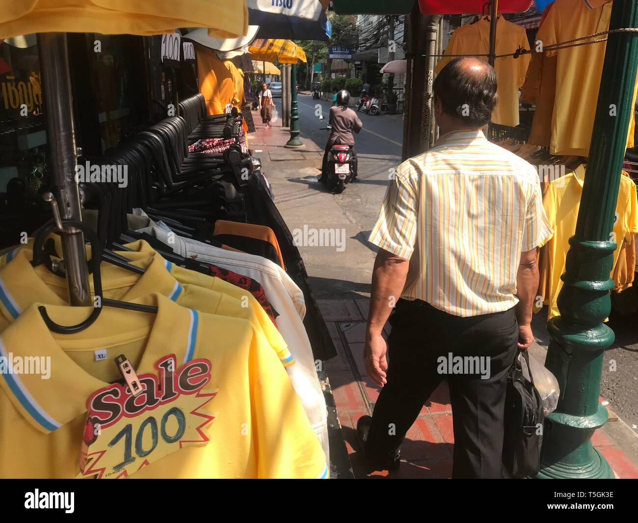 Bangkok, Thailand. 25 Apr, 2019. Gelbe polo shirts zu einem besonderen Preis von 100 Baht (umgerechnet etwa 2,80 Euro) hängen auf der Straße abgewürgt. Anlässlich der Krönung von König Maha Vajiralongkorn die Thais sollte alle Gelb tragen. (Dpa' Bangkok langsam gelb - Thais sollten Gelb tragen vor der Krönung 'Credit): Christoph Sator/dpa/Alamy leben Nachrichten Stockfoto