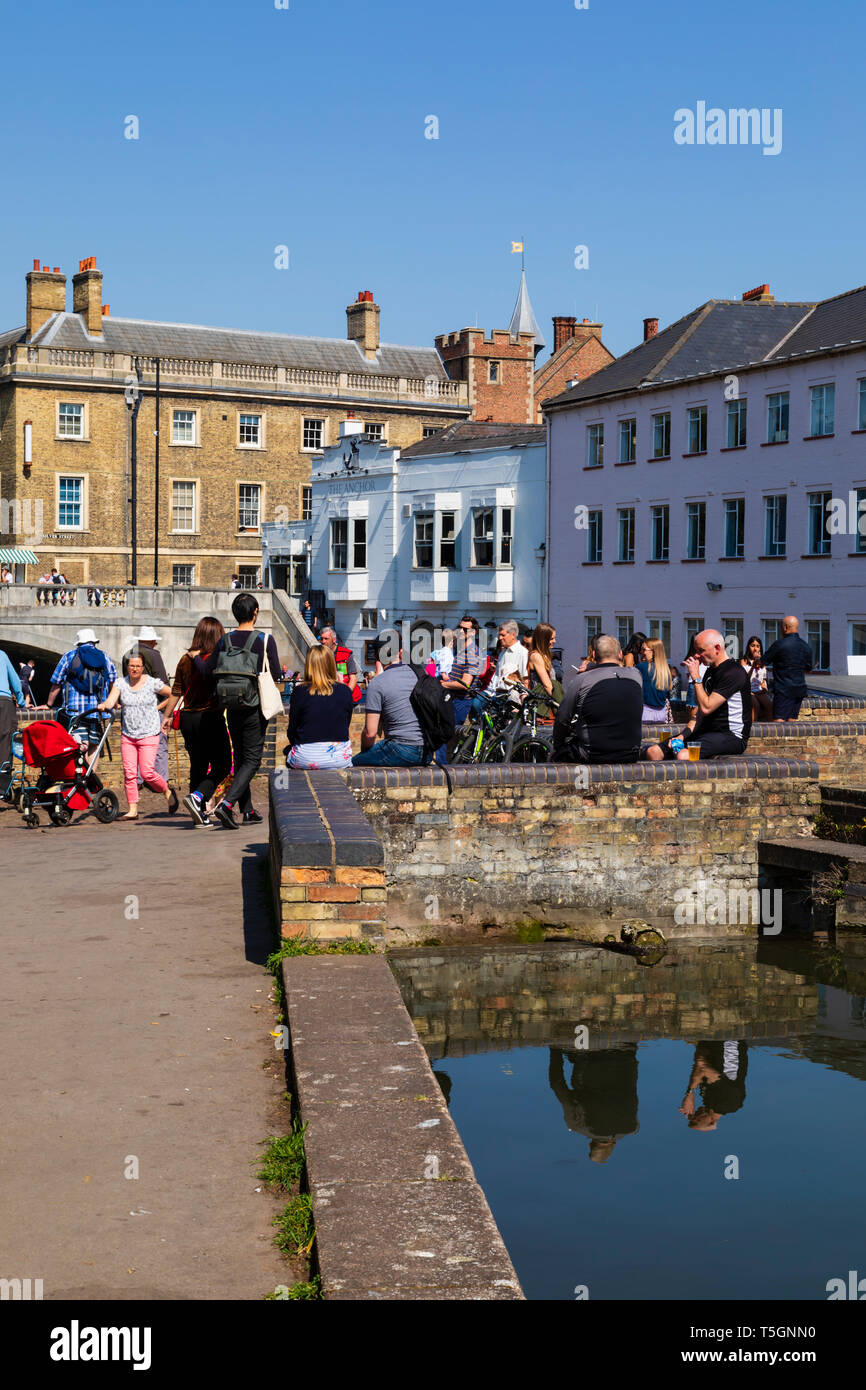 Touristen am Mill Race mit Blick auf den Mühlenteich auf dem Fluss Cam, Universitätsstadt Cambridge, Cambridgeshire, England entspannen Stockfoto