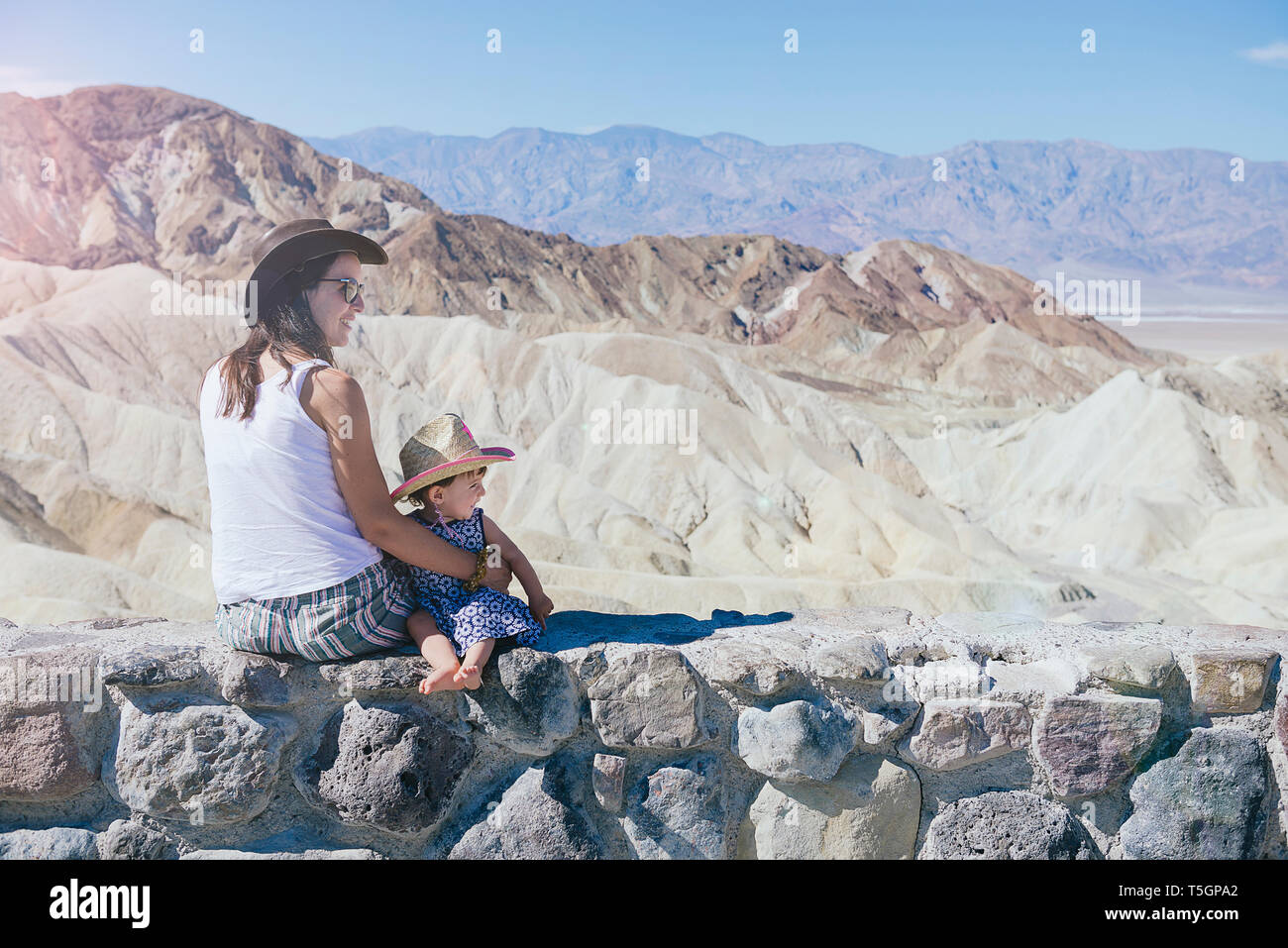 USA, Kalifornien, Death Valley National Park, 20 Mule Team Canyon, Mutter und Baby Mädchen sitzen auf Wand Stockfoto