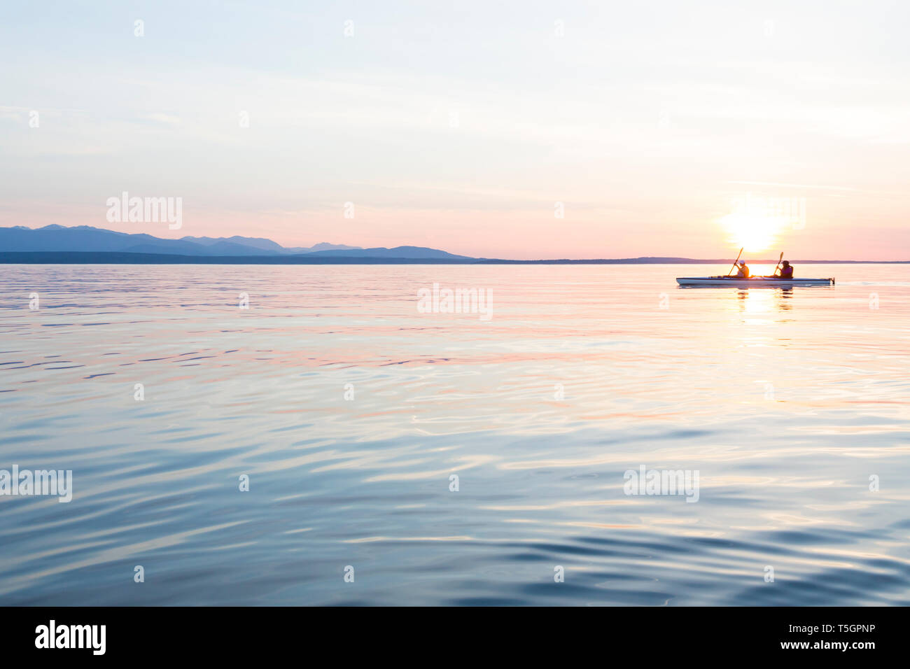 Menschen Frauen Kajak paddeln Boot in ruhigem Wasser bei Sonnenuntergang. Active Outdoor Abenteuer Wassersport. Reise, Ziel, Teamarbeit Konzepte. Stockfoto
