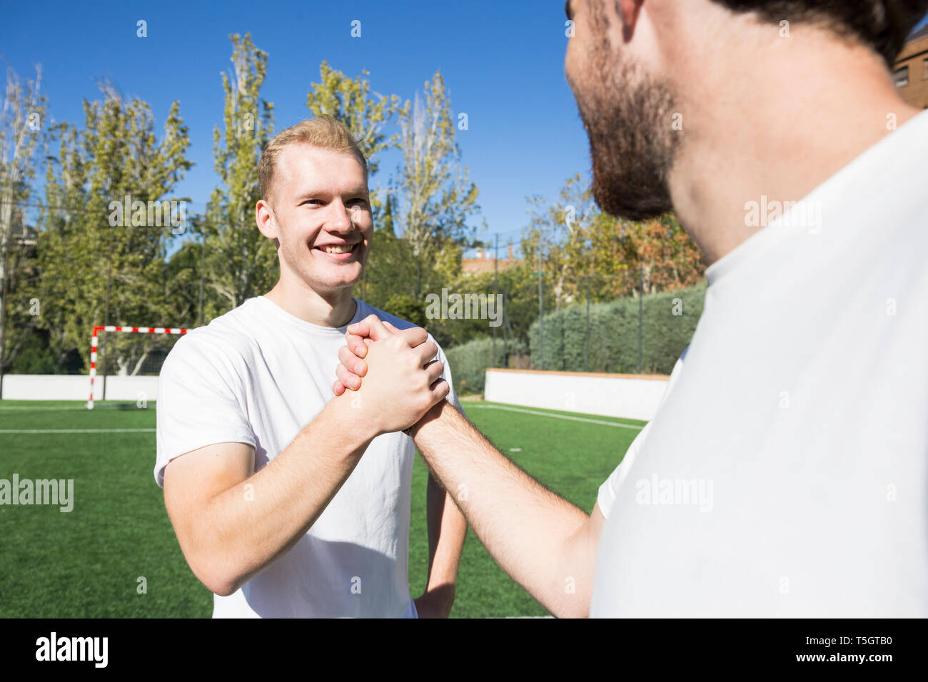 Zwei Fußball-Spieler die Hände schütteln auf Fußball-Feld Stockfoto