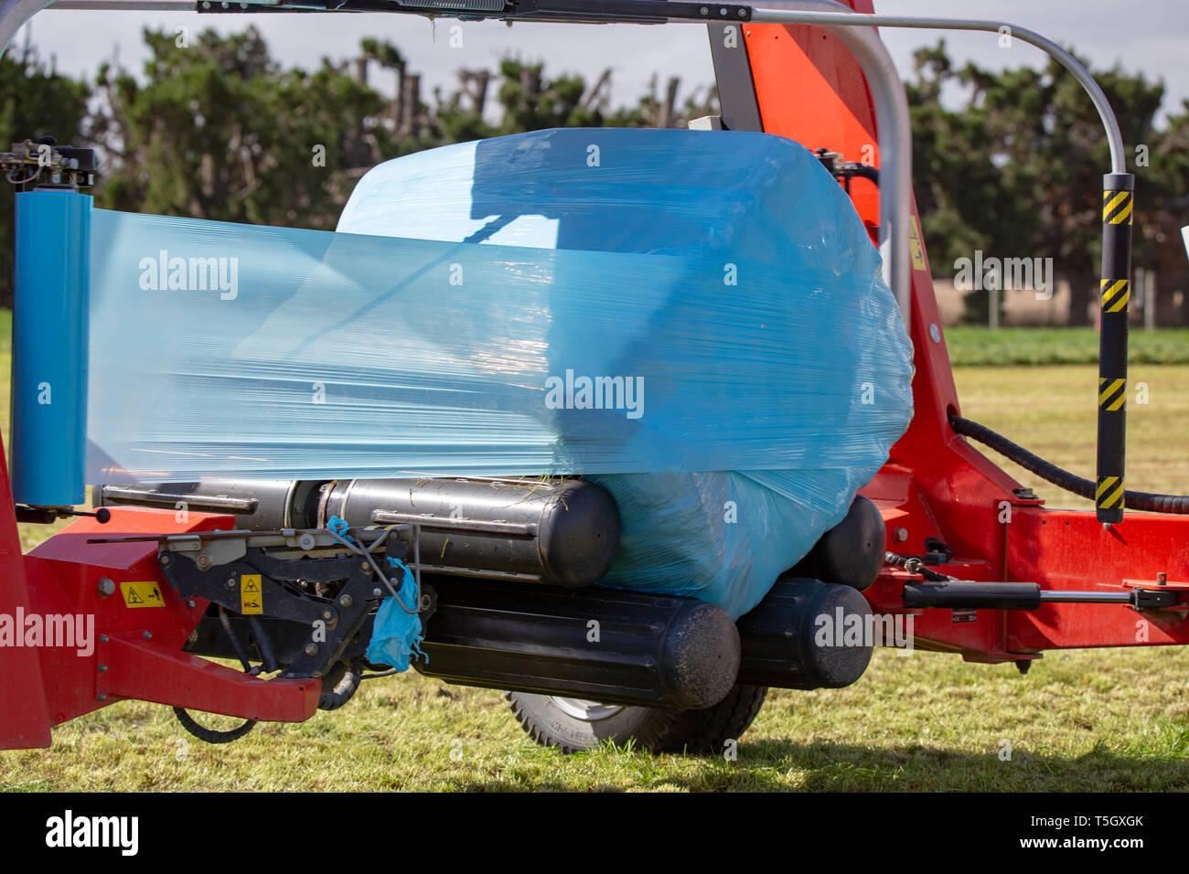 Kirwee, Canterbury, Neuseeland, 27. März 2019: eine Demonstration der Hay wrapper bei der Arbeit auf der Südinsel landwirtschaftliches Feld Tage Veranstaltung Stockfoto