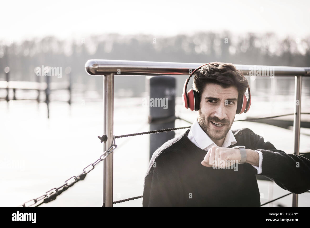 Geschäftsmann auf einem Hausboot mit smartwatch, einen Anruf zu tätigen, das Tragen von Kopfhörern Stockfoto