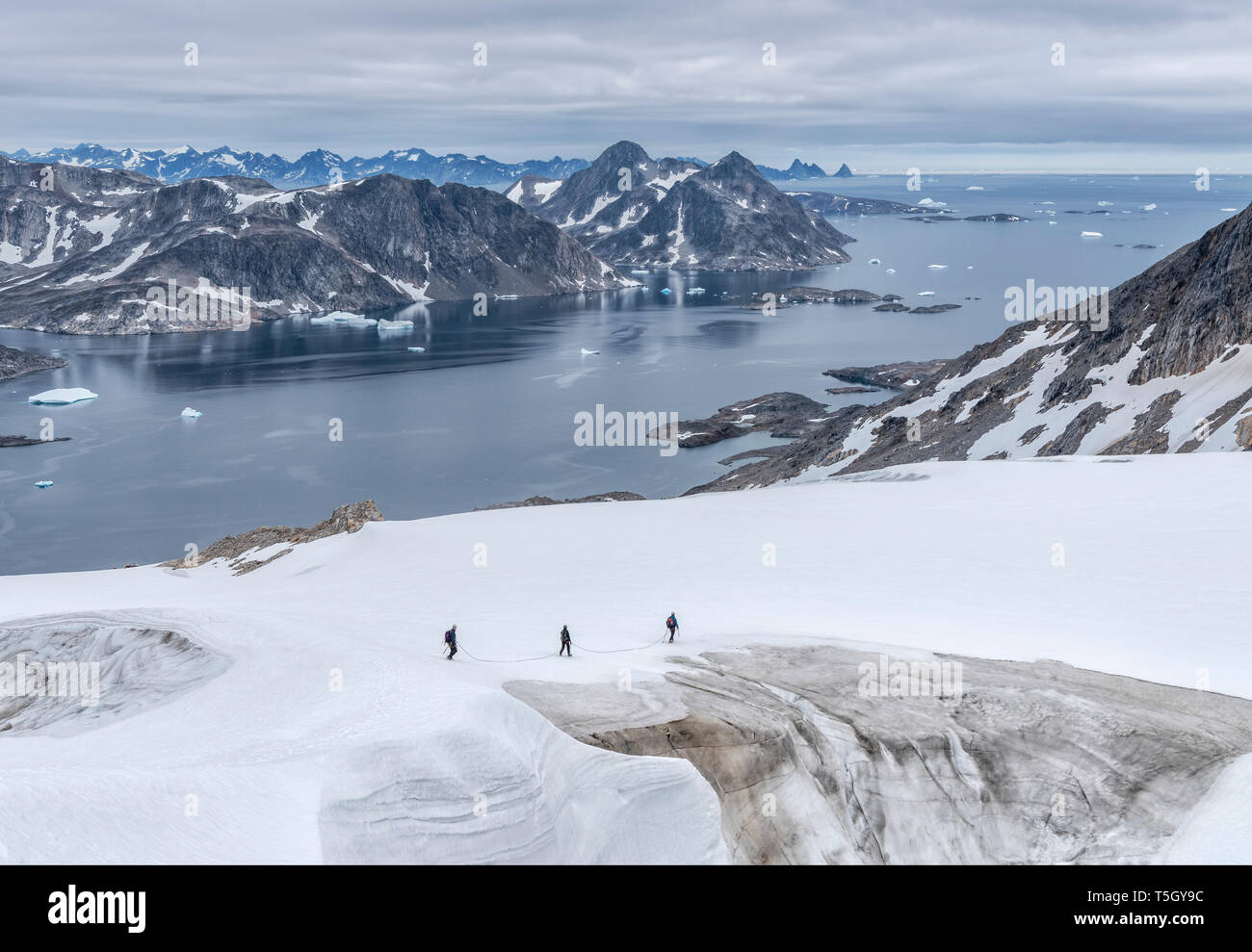 Grönland, Sermersooq, Kulusuk, Schweizerland Alpen, drei Menschen zu Fuß im Schnee Stockfoto