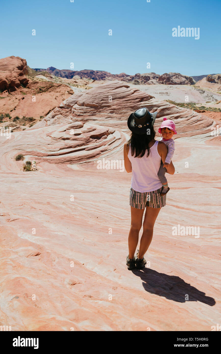 USA, Nevada, Valley of Fire State Park, Rückansicht von Mutter und Baby Mädchen beobachten Landschaft Stockfoto