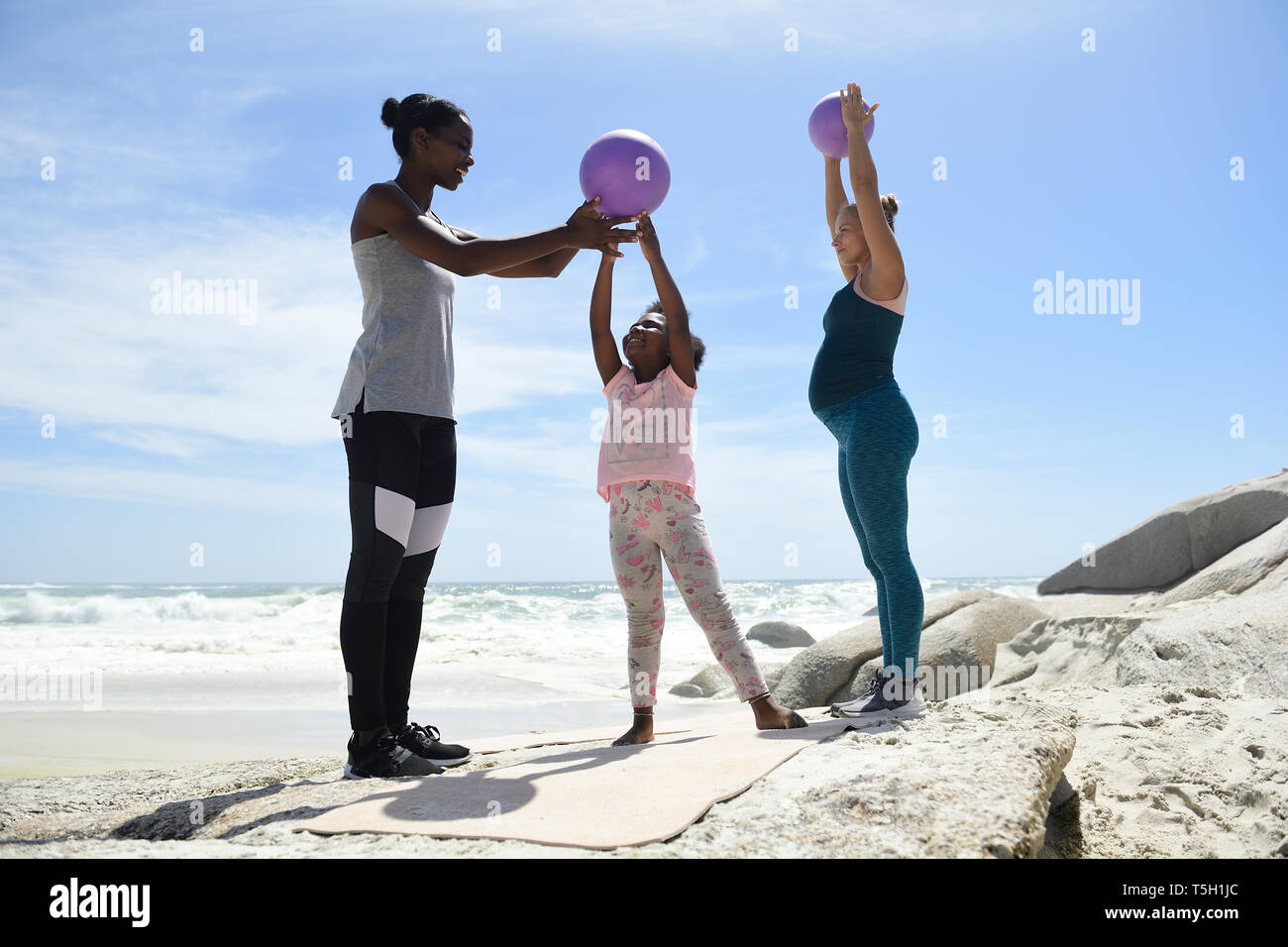 Mutter mit Tochter und Freund Training mit einem Ball am Strand Stockfoto
