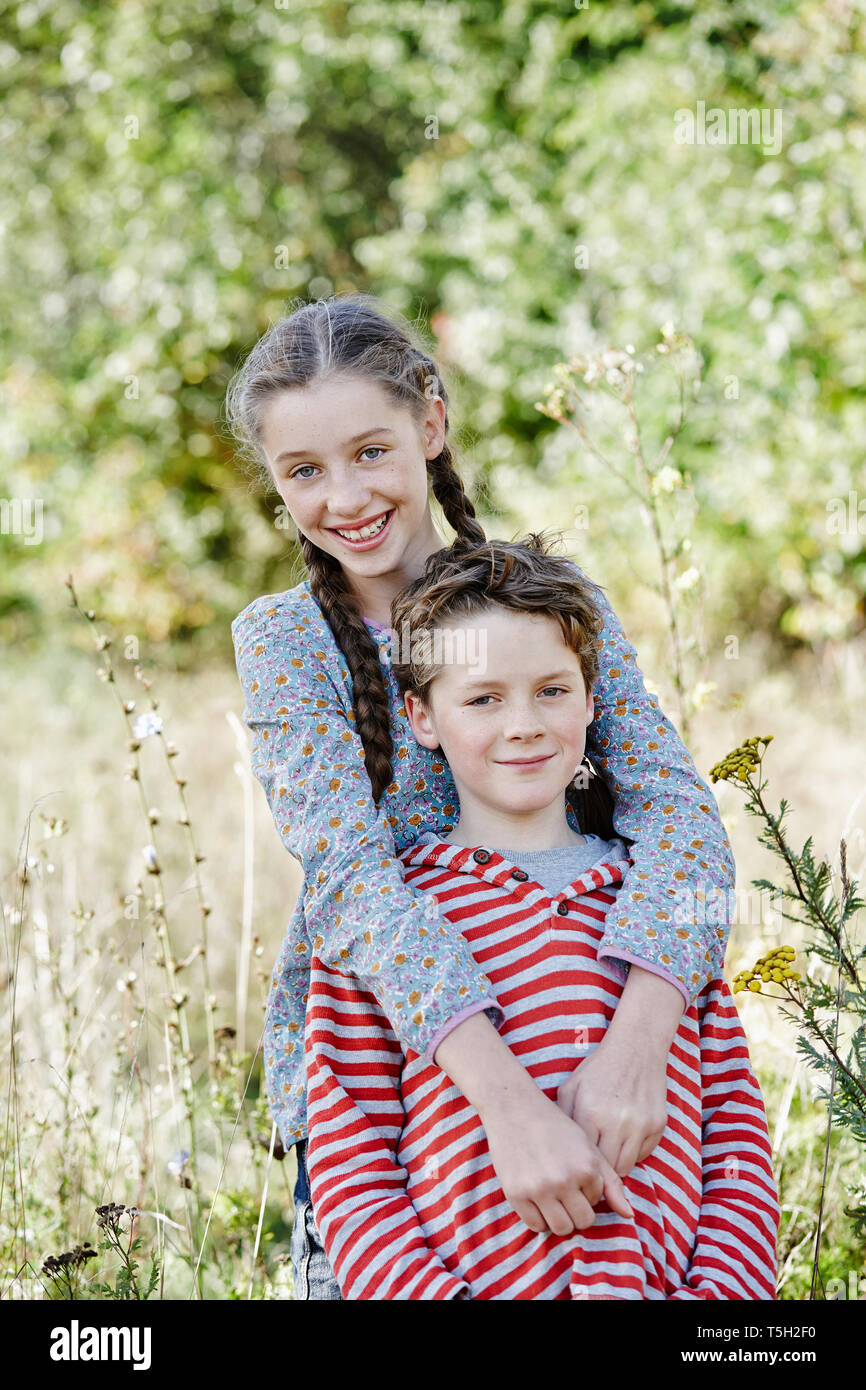 Porträt der lächelnde Mädchen und kleiner Bruder in der Natur Stockfoto