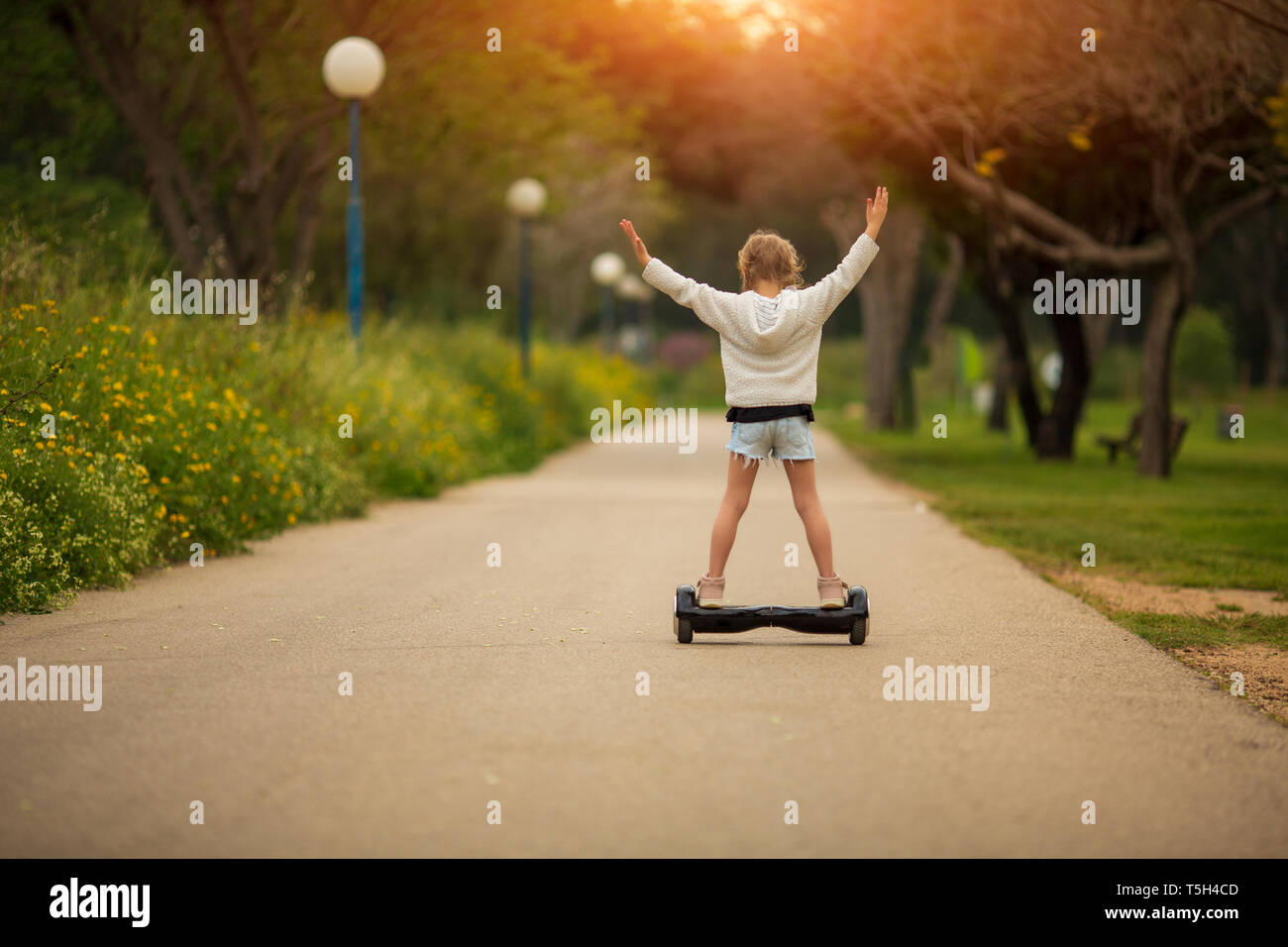 Kleines Mädchen Reiten eines elektrischen scooter. Persönliche eco Transport, gyro Roller, smart Balance Wheel Stockfoto