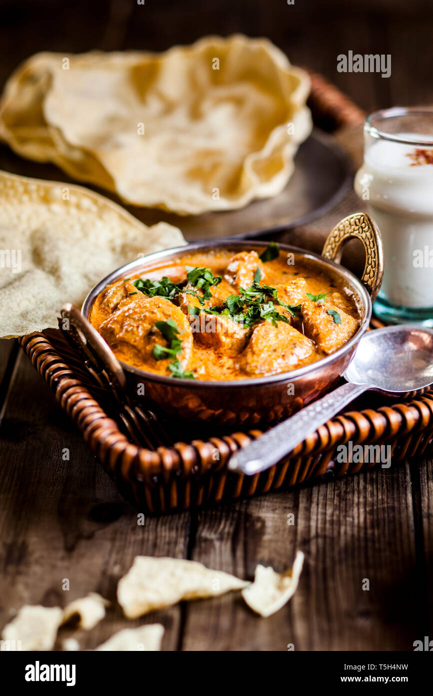 Indian Butter Chicken mit Papadam, Reis, und Lassi Stockfoto