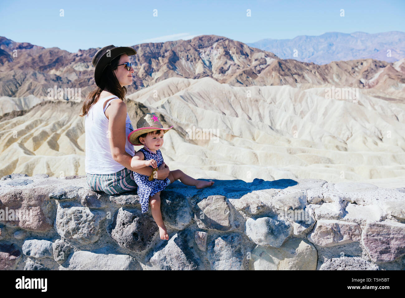 USA, Kalifornien, Death Valley National Park, 20 Mule Team Canyon, Mutter und Baby Mädchen sitzen auf Wand Stockfoto