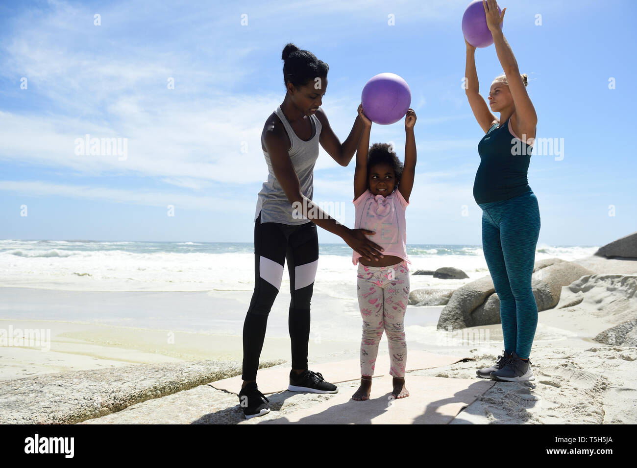 Mutter mit Tochter und Freund Training mit einem Ball am Strand Stockfoto