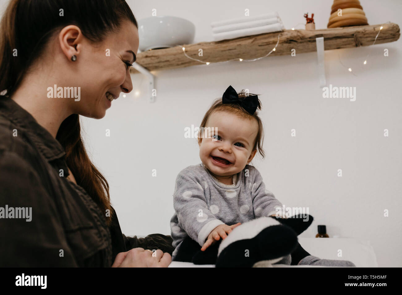 Glückliche Mutter mit Baby Mädchen in Babys Zimmer zu Hause Stockfoto