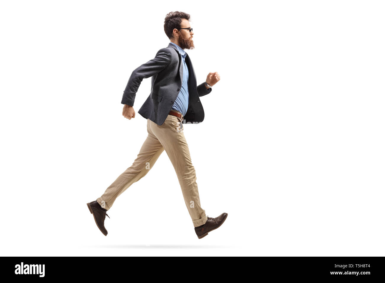 Volle Länge geschossen von einem bärtigen Mann in formelle Kleidung auf weißem Hintergrund läuft Stockfoto