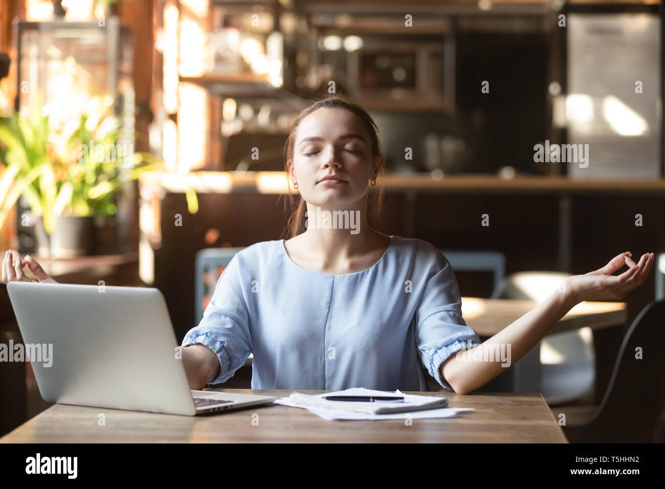 Junge Frau sitzt an einem Tisch in Cafe entspannen Sie Meditation Stockfoto