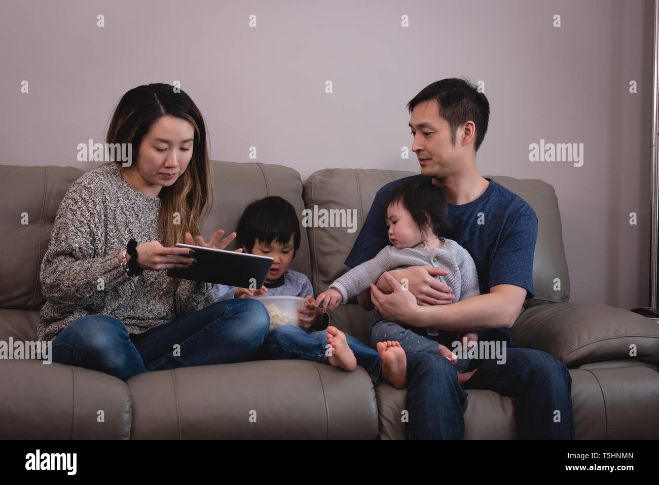 Familie zusammen genießen, während auf dem Sofa zu Hause sitzen Stockfoto
