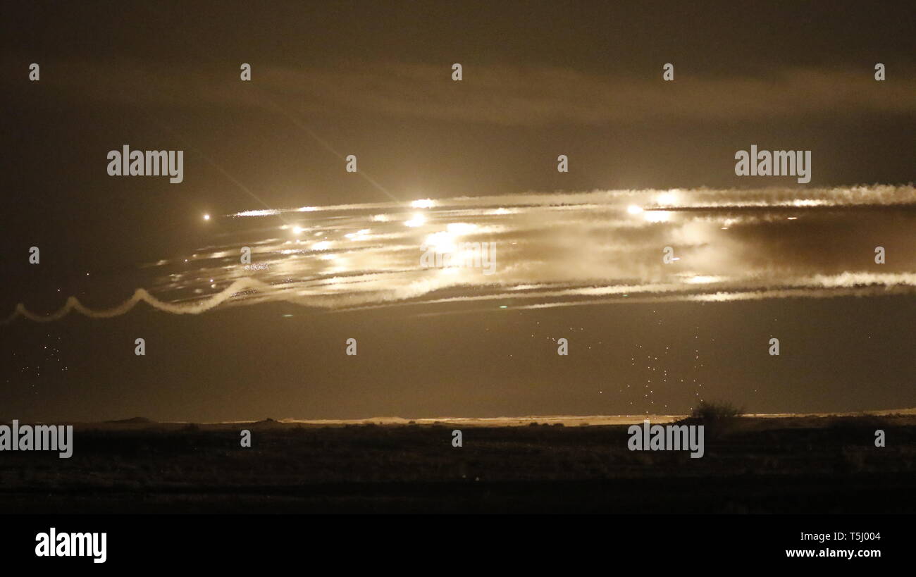 Usa und Qatari Artillerie Feuer beleuchtet den Nachthimmel bei Umm Hawta, Katar am 3. April 2019. Soldaten zur Unterstützung der Task Force Spartan in Kuwait stationiert nahm zu den Himmel mit zwei high-mobility Artillery Rocket System Trägerraketen. Mitglieder der Bravo Batterie, 5 Bataillon, 113 Field Artillery, North Carolina National Guard in einem C-17 Flugzeuge der Luftwaffe des Emirs von Katar gereist in Katar zu landen und Schießen in einem gemeinsamen Leben - Feuer mit dem Katarischen des Emirs Land Kräfte, die ihre Artillerie Sättigung Rocket System feuerte (ASTROS II) während der Übung Al Adheed 2019, veranstaltet von der Landstreitkräfte des Emirs von Katar. (U. Stockfoto