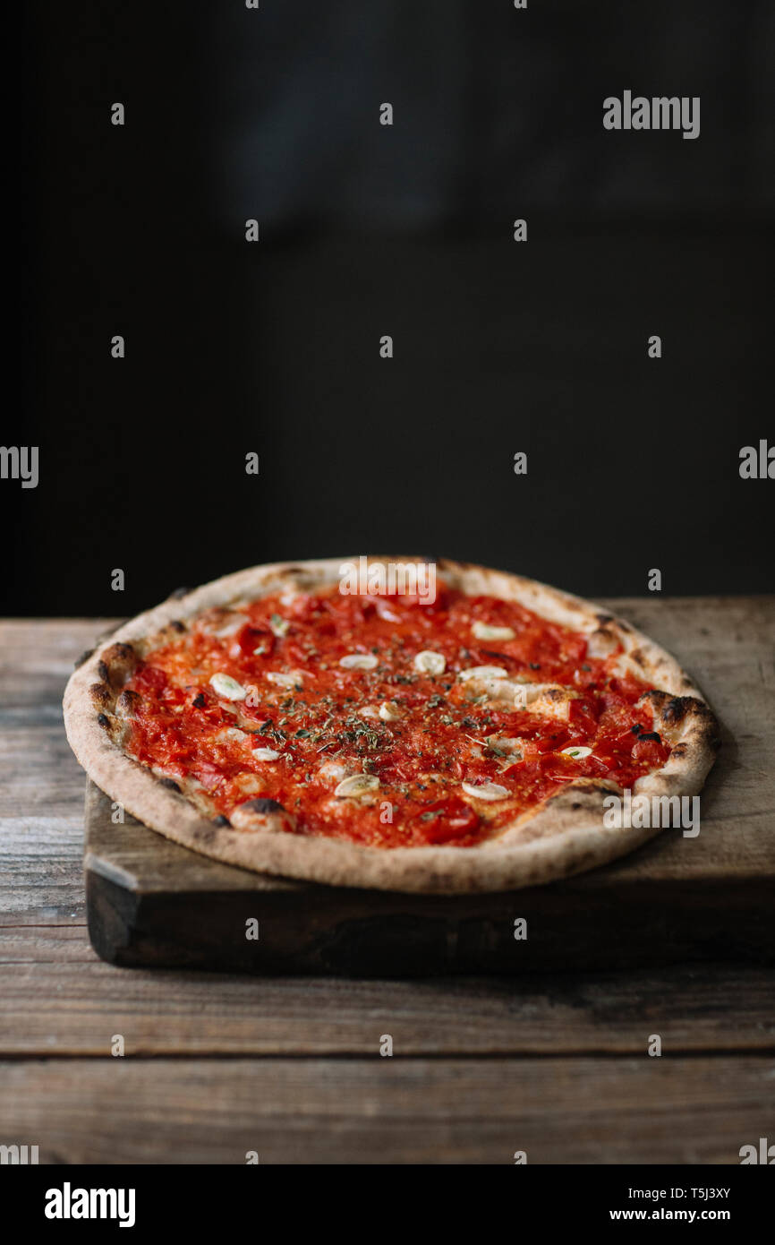 Pizza Margherita auf Schneidebrett Stockfoto