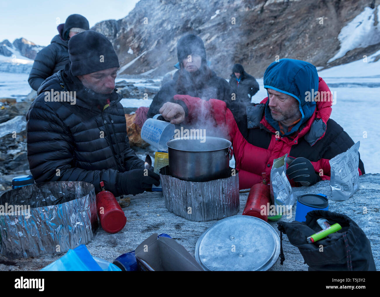 Grönland, Sermersooq, Kulusuk, Schweizerland Alpen, Gruppe von Menschen mit einer Unterbrechung Kochen von Wasser Stockfoto