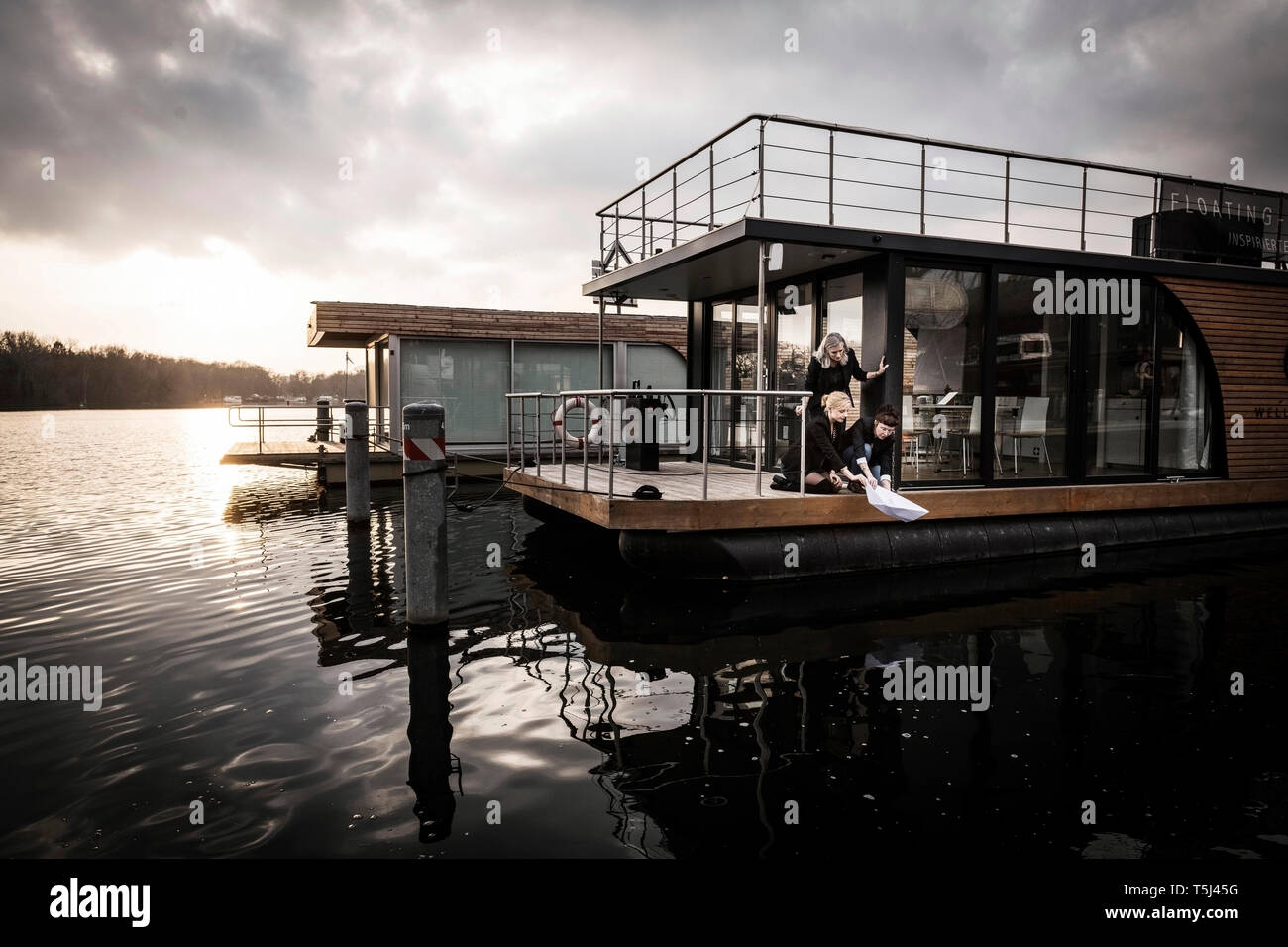 Drei Kollegen Vermietung paperboat ins Wasser. Stockfoto